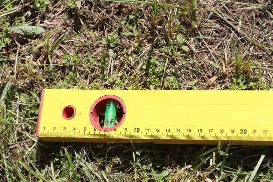 Close up of a measuring tool laying on natural turf surface