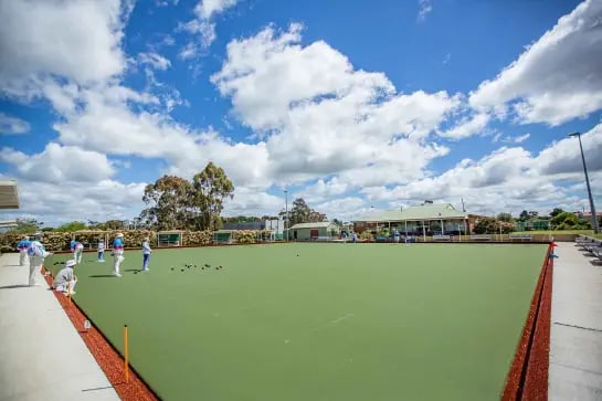 Panoramic view of players on a lawn bowls synthetic turf field