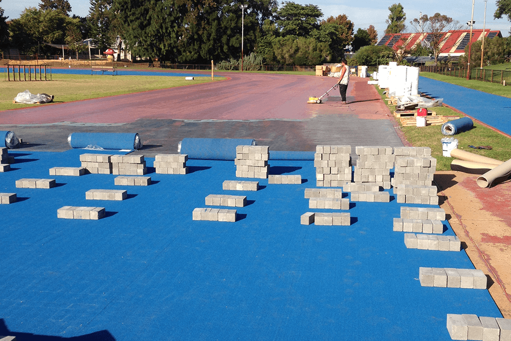 Installation of a prefabricated overlay system on an athletic track