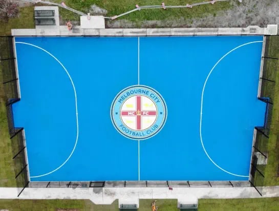 Aerial view of an outdoor blue synthetic surface soccer sports field