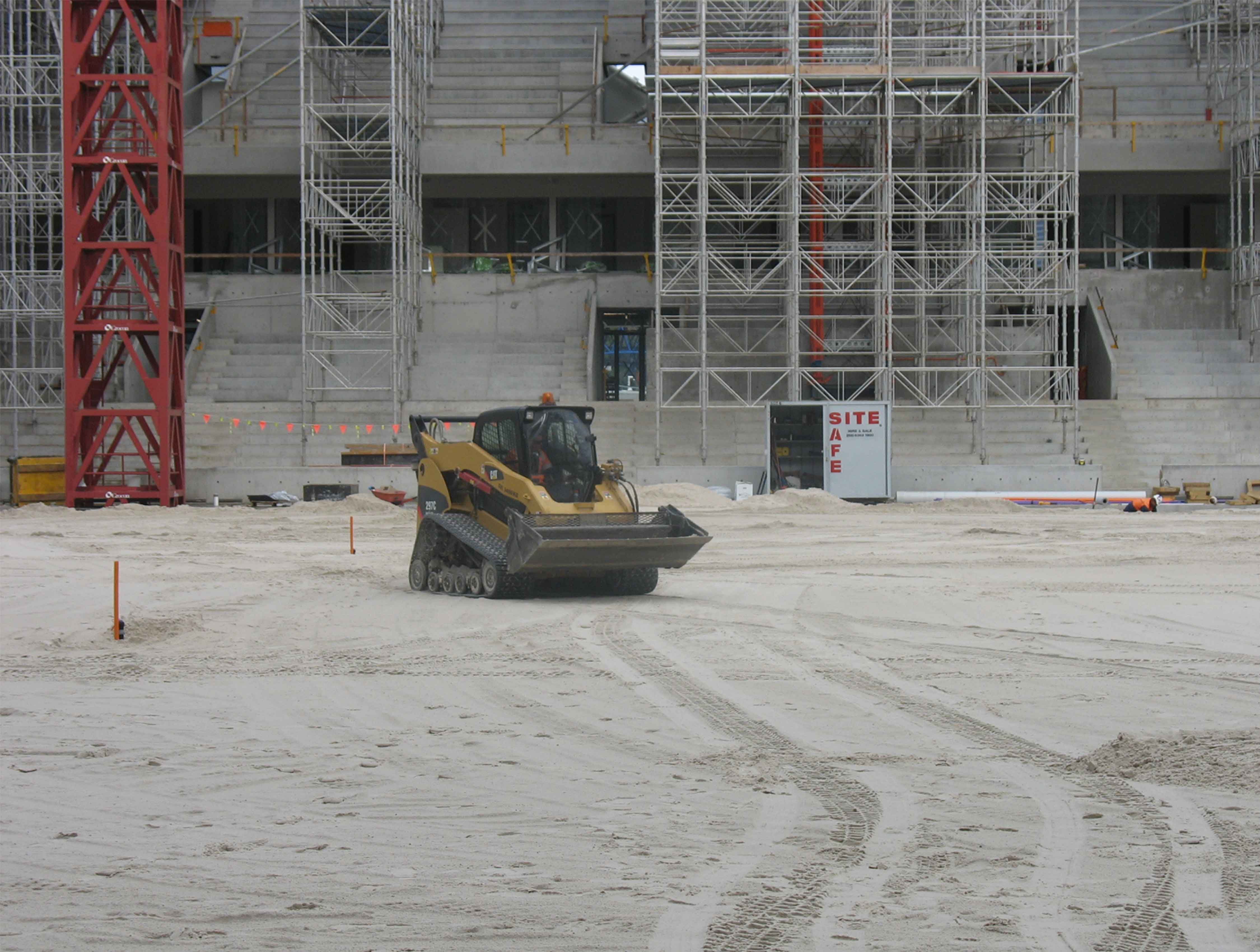 Machinery being drove on a construction site for a stadium sportsfield