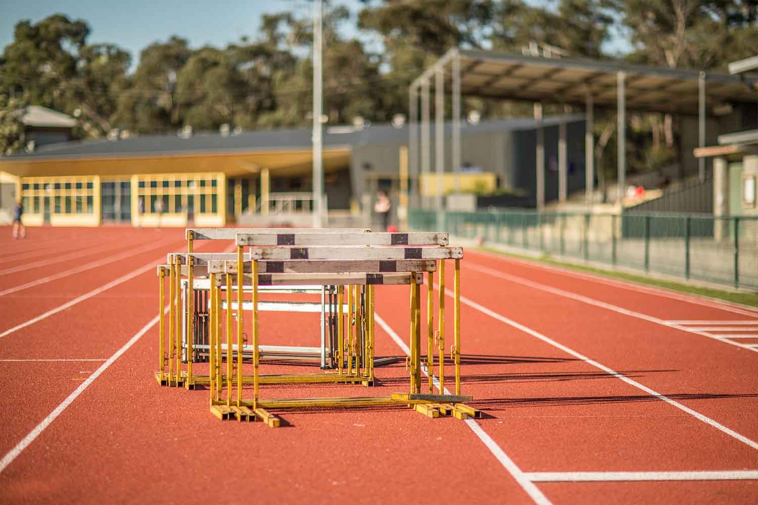 Stack of jumping bars in the middle of red outdoor athletic running tracks