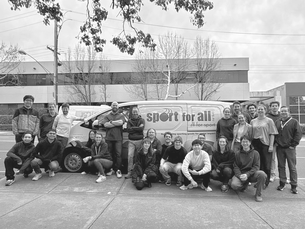 Group of people posing in front of a charity van